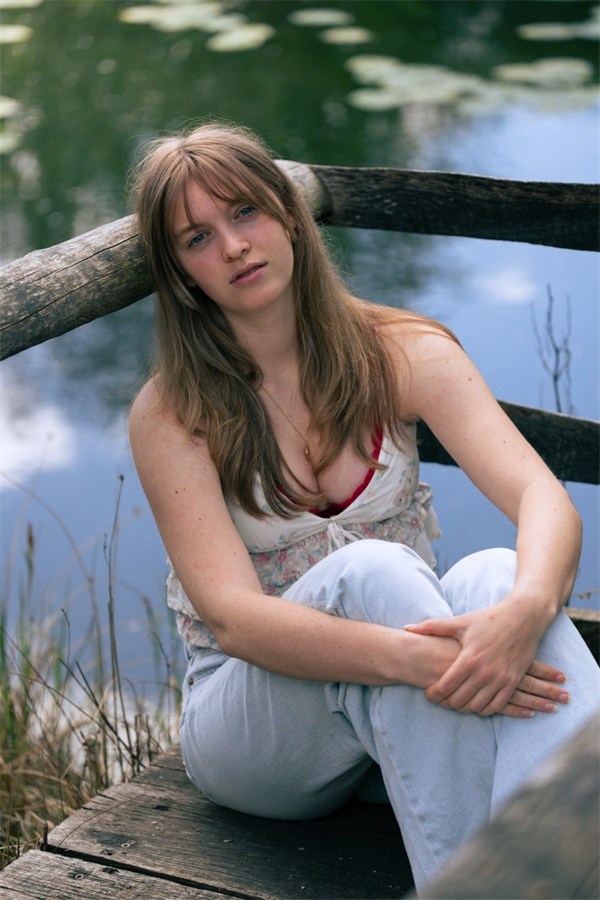 Portrait of a woman seated beside a pond